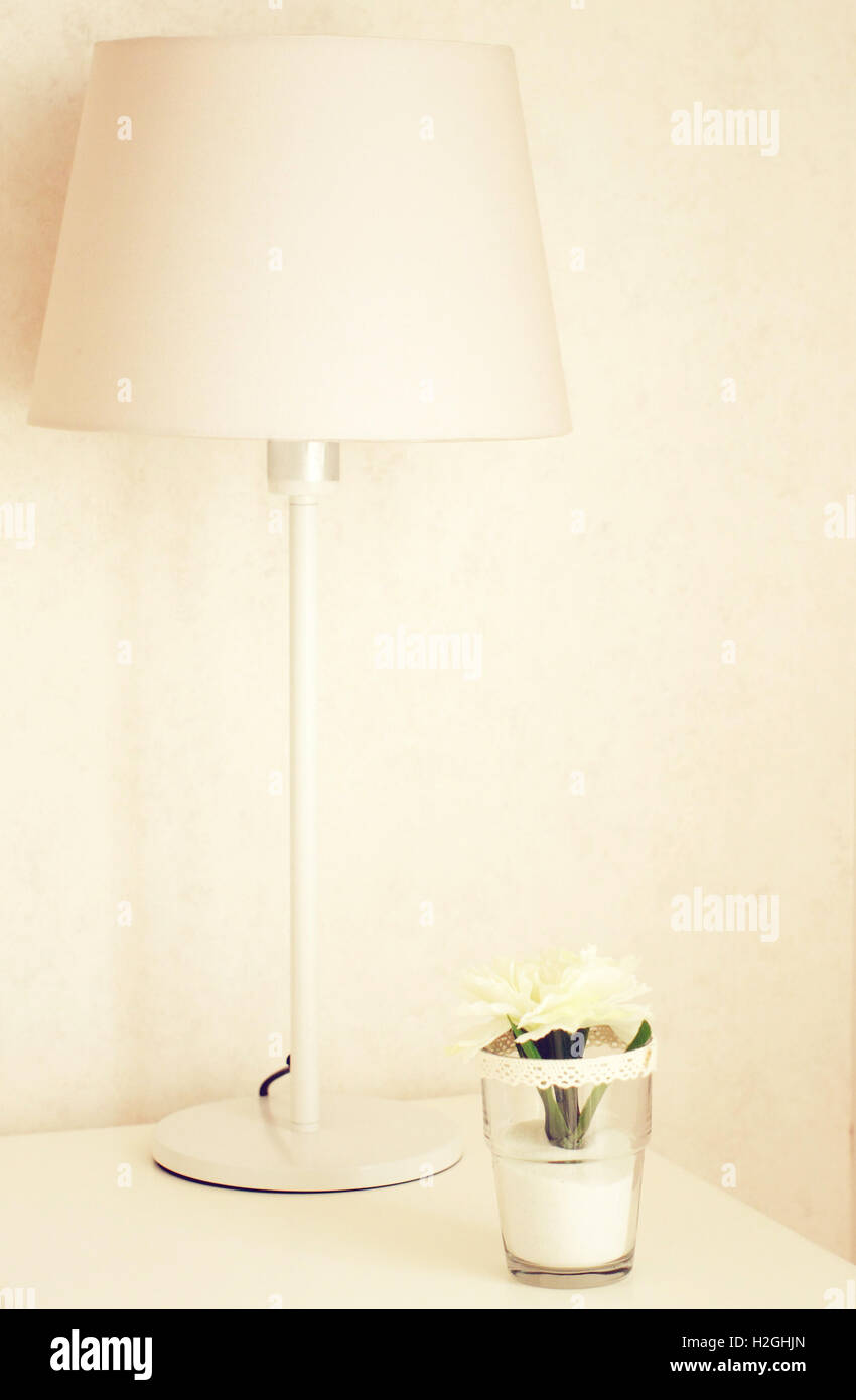 Lampe et fleur sur la table près de lit avec effet filtre rétro Banque D'Images