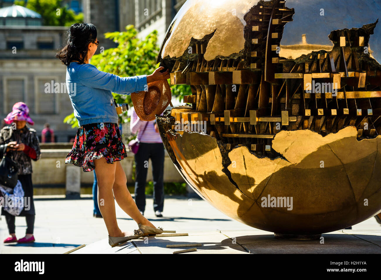 Les visiteurs bénéficient dans la sphère sphère (Sfera con sfera) sculpture d'Arnaldo Pomodoro, Trinity College Dublin, Irlande Banque D'Images