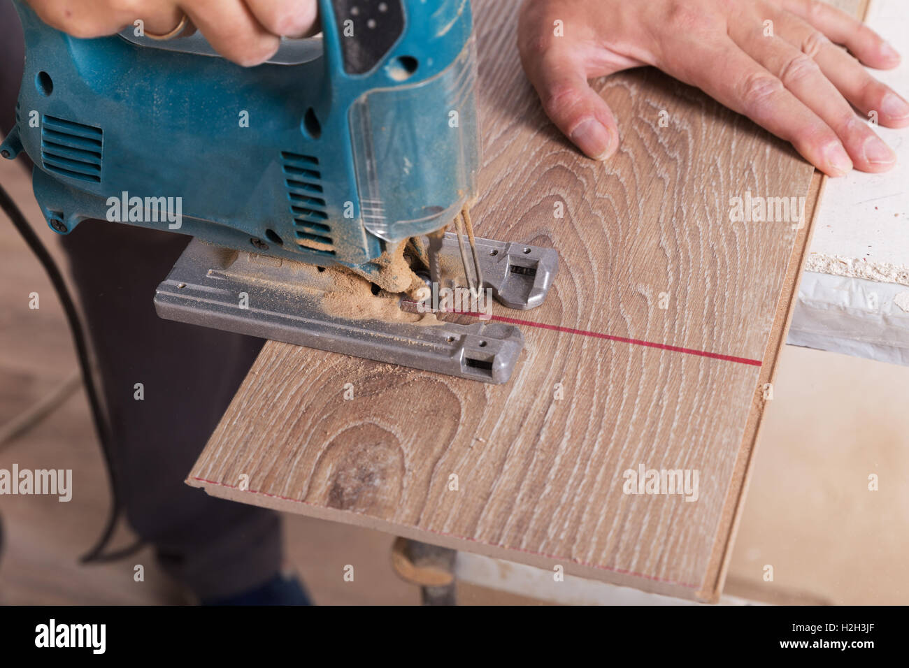 L'installation de parquet stratifié. Carpenter couper parquet board avec  electric jigsaw Photo Stock - Alamy