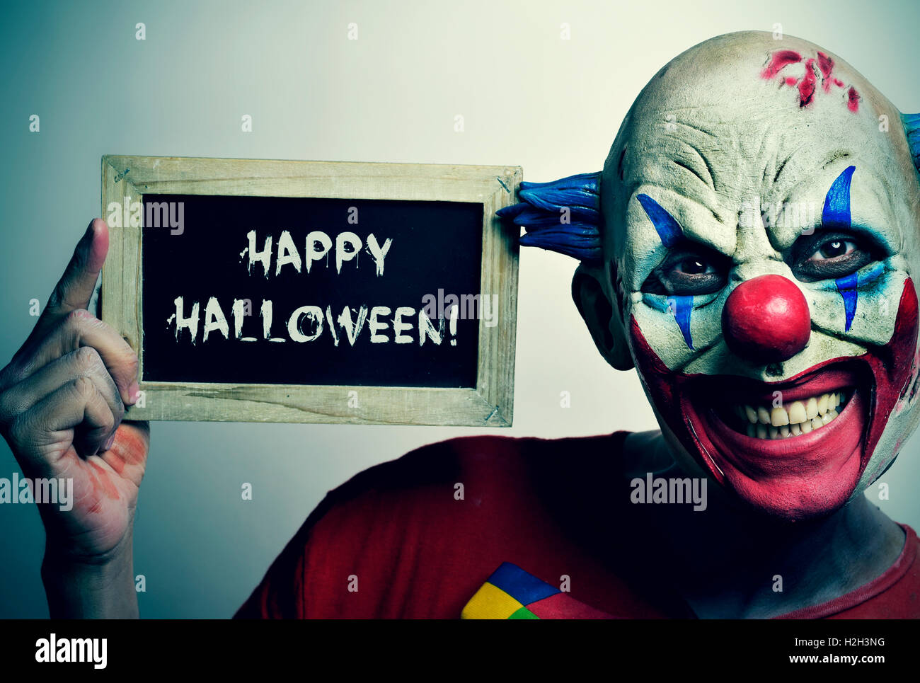 Portrait D Un Clown Malefique Effrayant Avec Un Tableau Sur Le Texte Ecrit En C Est L Halloween Photo Stock Alamy