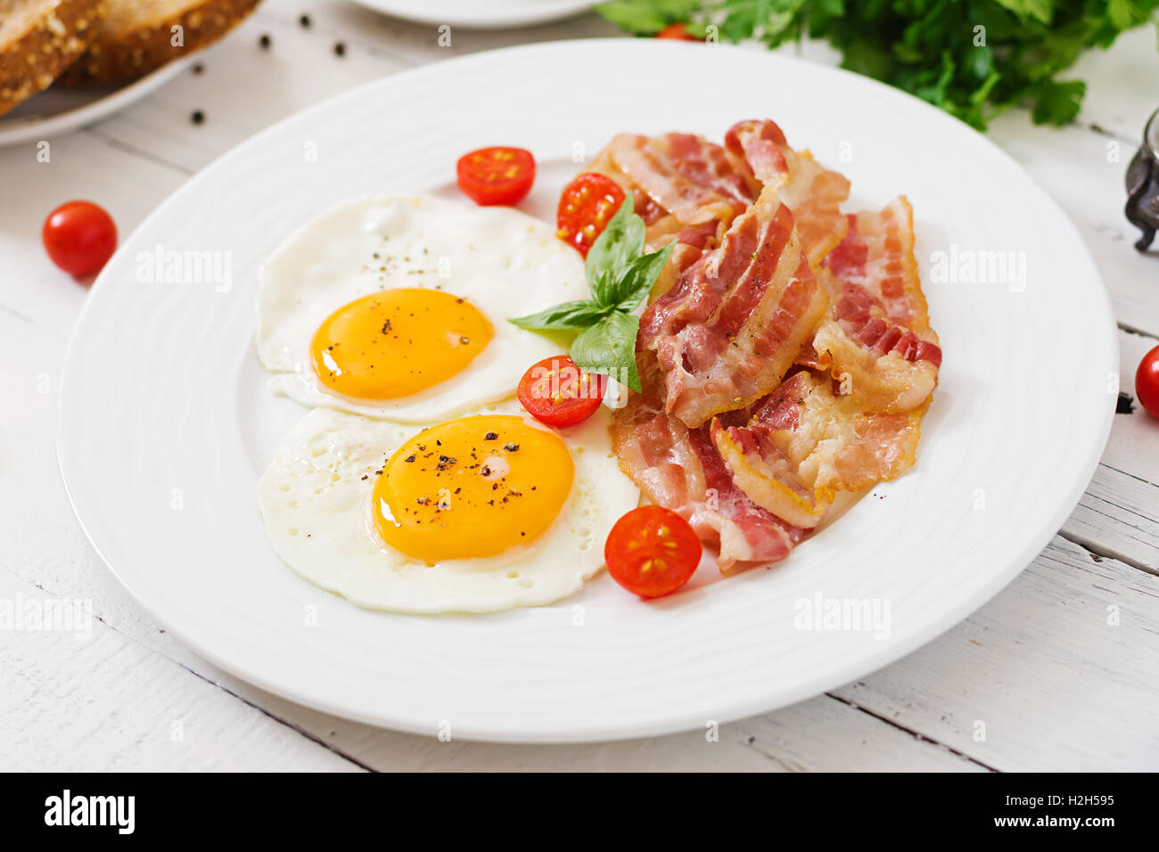 Petit-déjeuner anglais - œuf frit, tomates et bacon. Banque D'Images