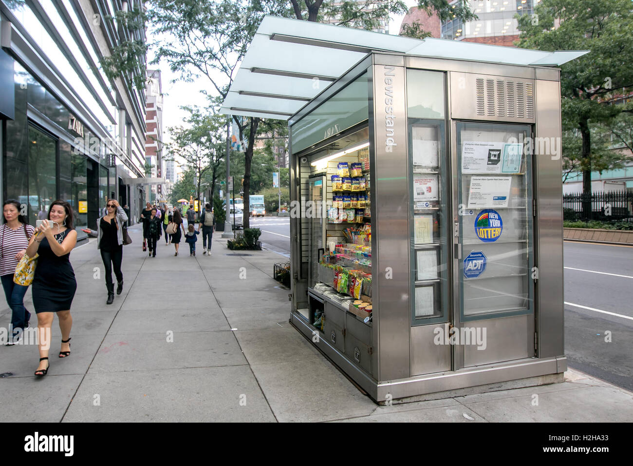 Les gens à pied par un kiosque à Manhattan. Banque D'Images