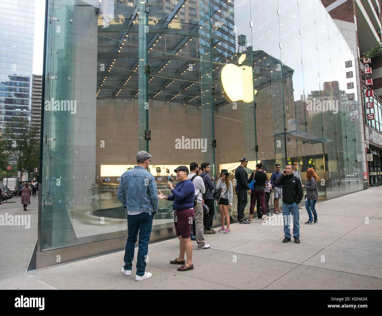 Les gens font la queue devant un Apple Store en prévision de son ouverture. Banque D'Images