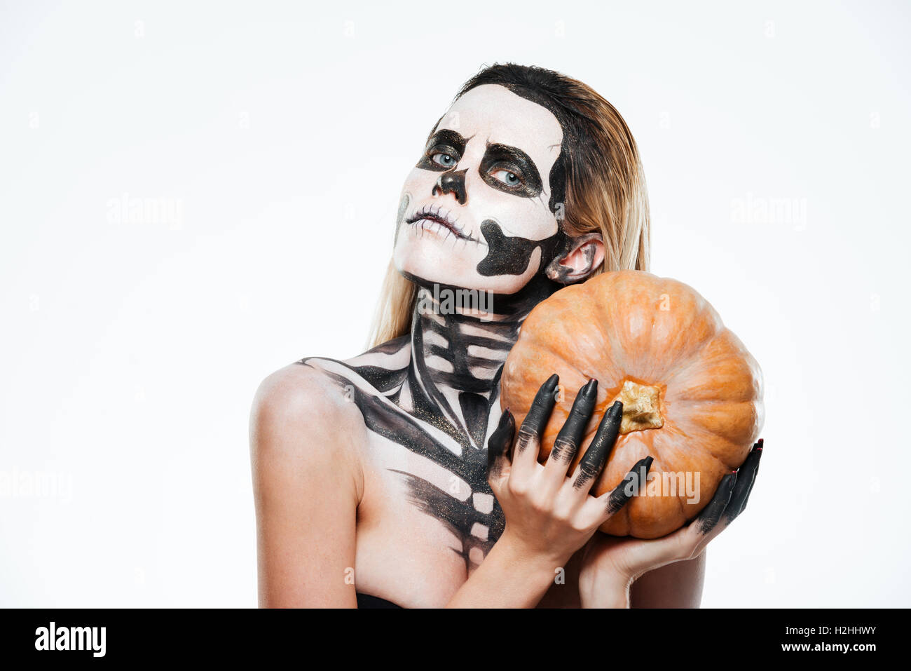 Portrait de femme avec squelette halloween citrouille holding maquillage sur fond blanc Banque D'Images