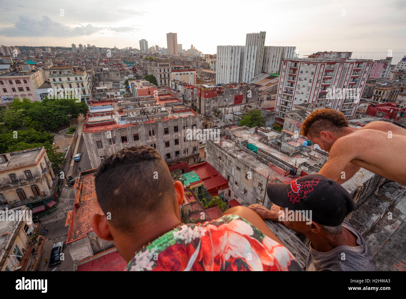 Trois personnes à par-dessus le bord d'un bâtiment dans le centre de La Havane, Cuba. Banque D'Images