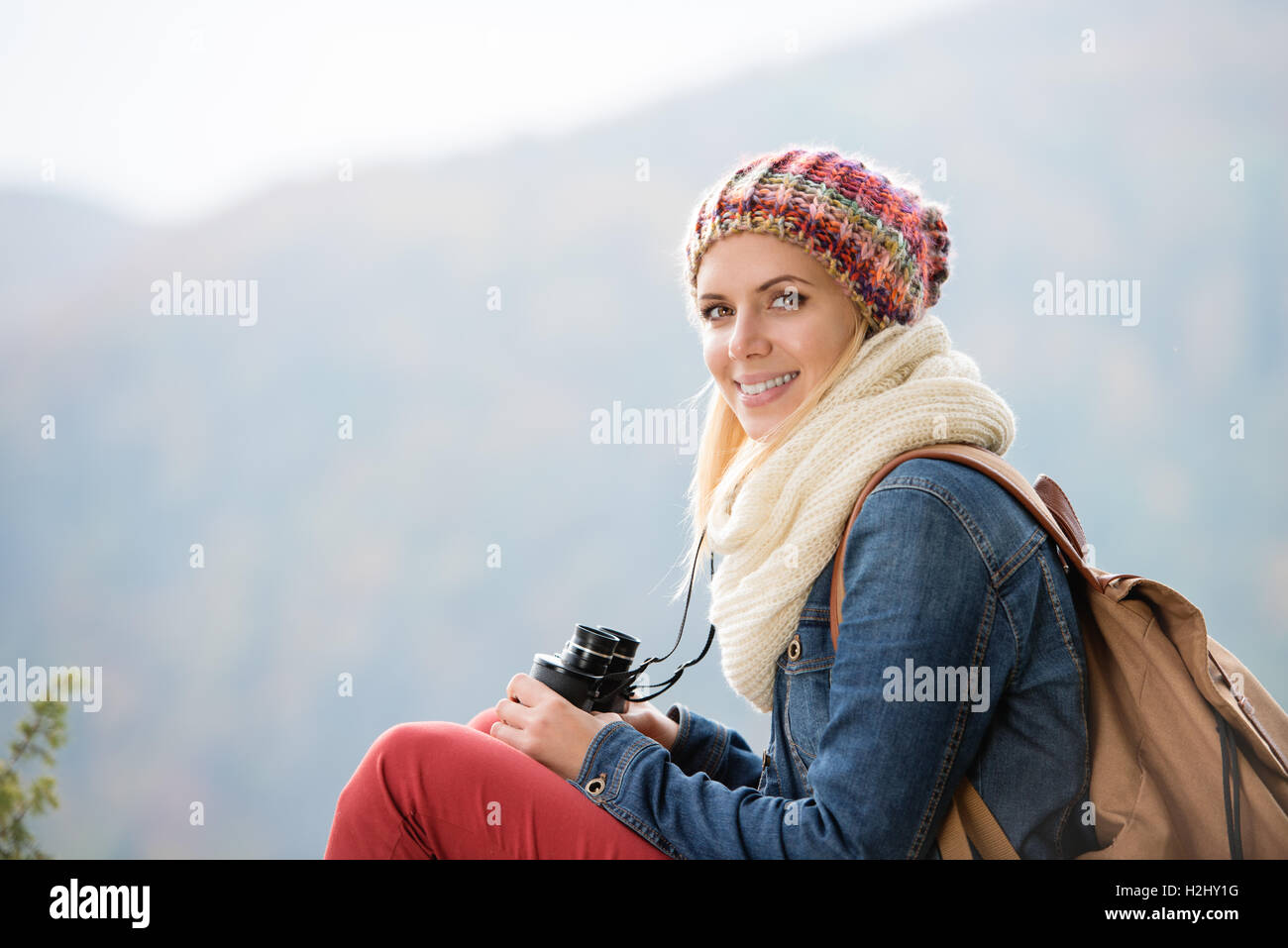 Belle Jeune femme tenant des jumelles, l'automne ensoleillé coloré Banque D'Images
