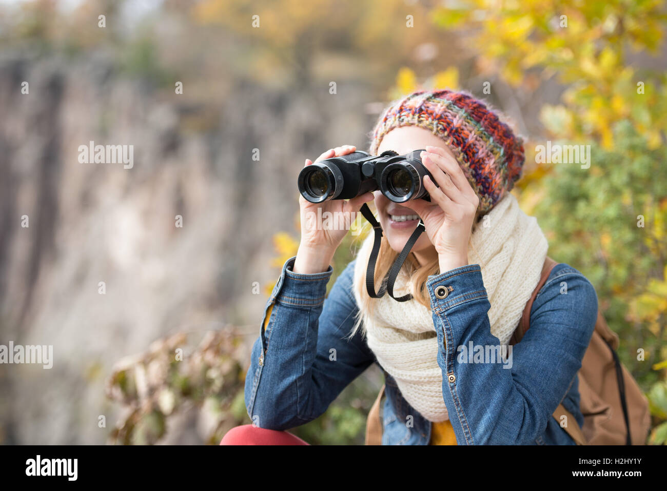 Belle femme regardant à travers des jumelles, l'automne ensoleillé coloré Banque D'Images