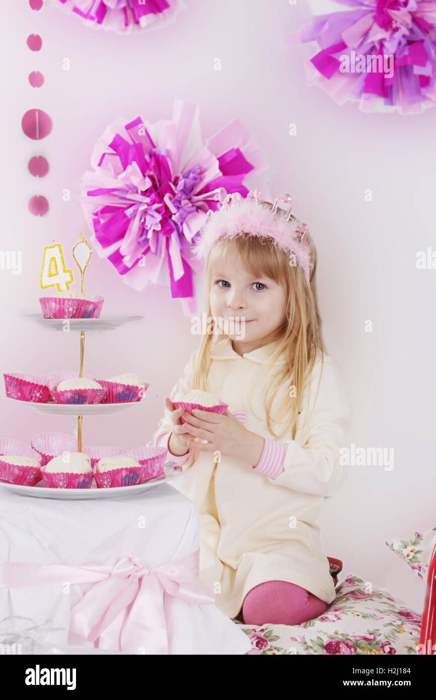 Fille avec du gâteau d'anniversaire décoration rose à Banque D'Images