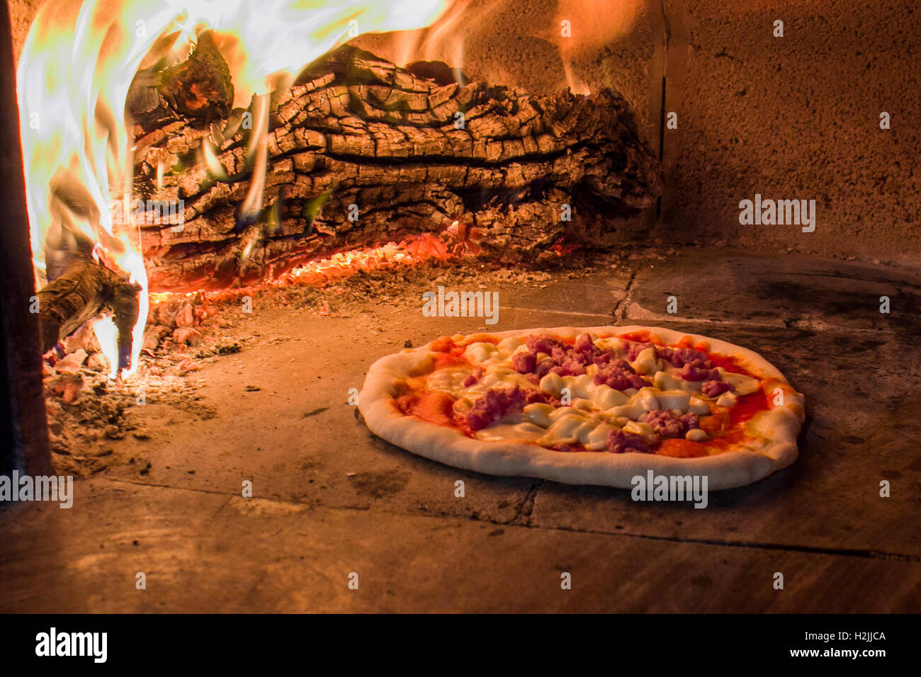 Pizza à la saucisse dans un four à bois Banque D'Images