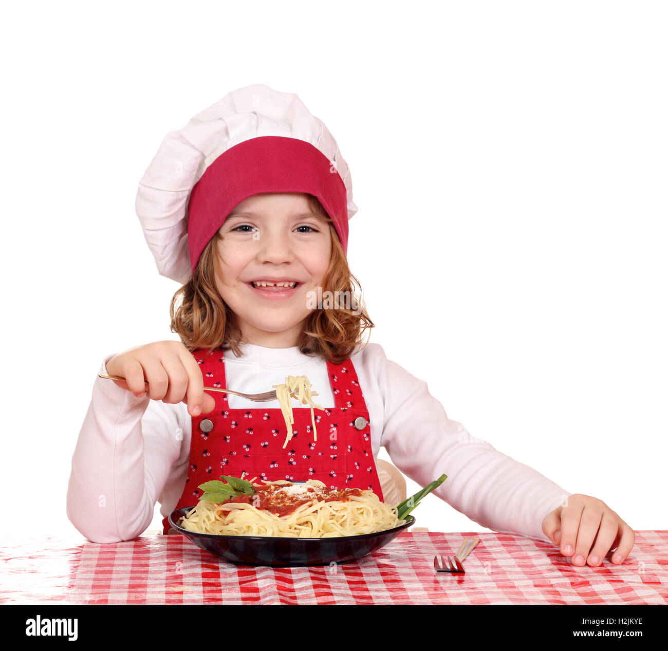 Happy little girl cook manger de spaghettis Banque D'Images