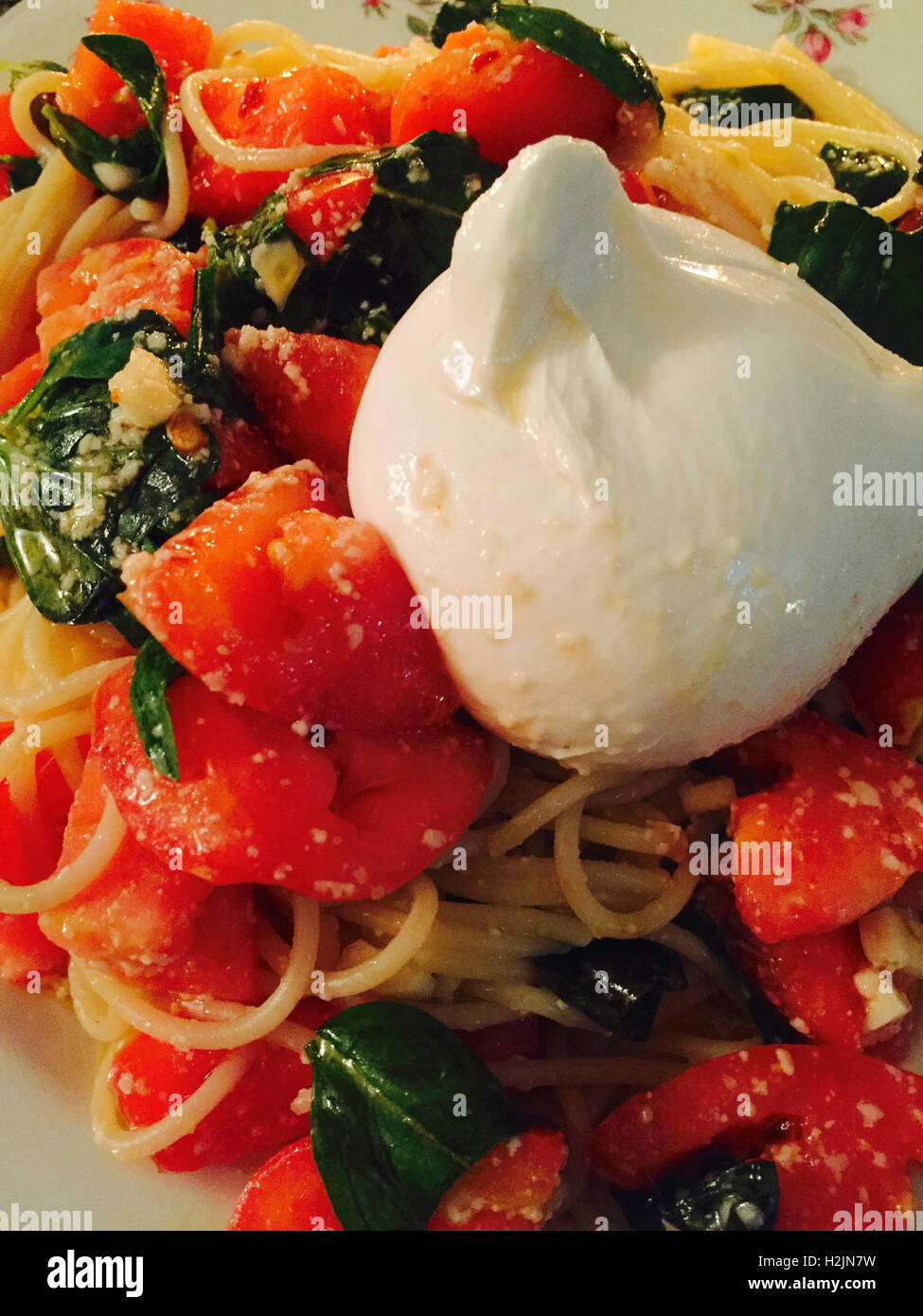 Un plat de pâtes avec du fromage Burrata, tomate et basilic Banque D'Images