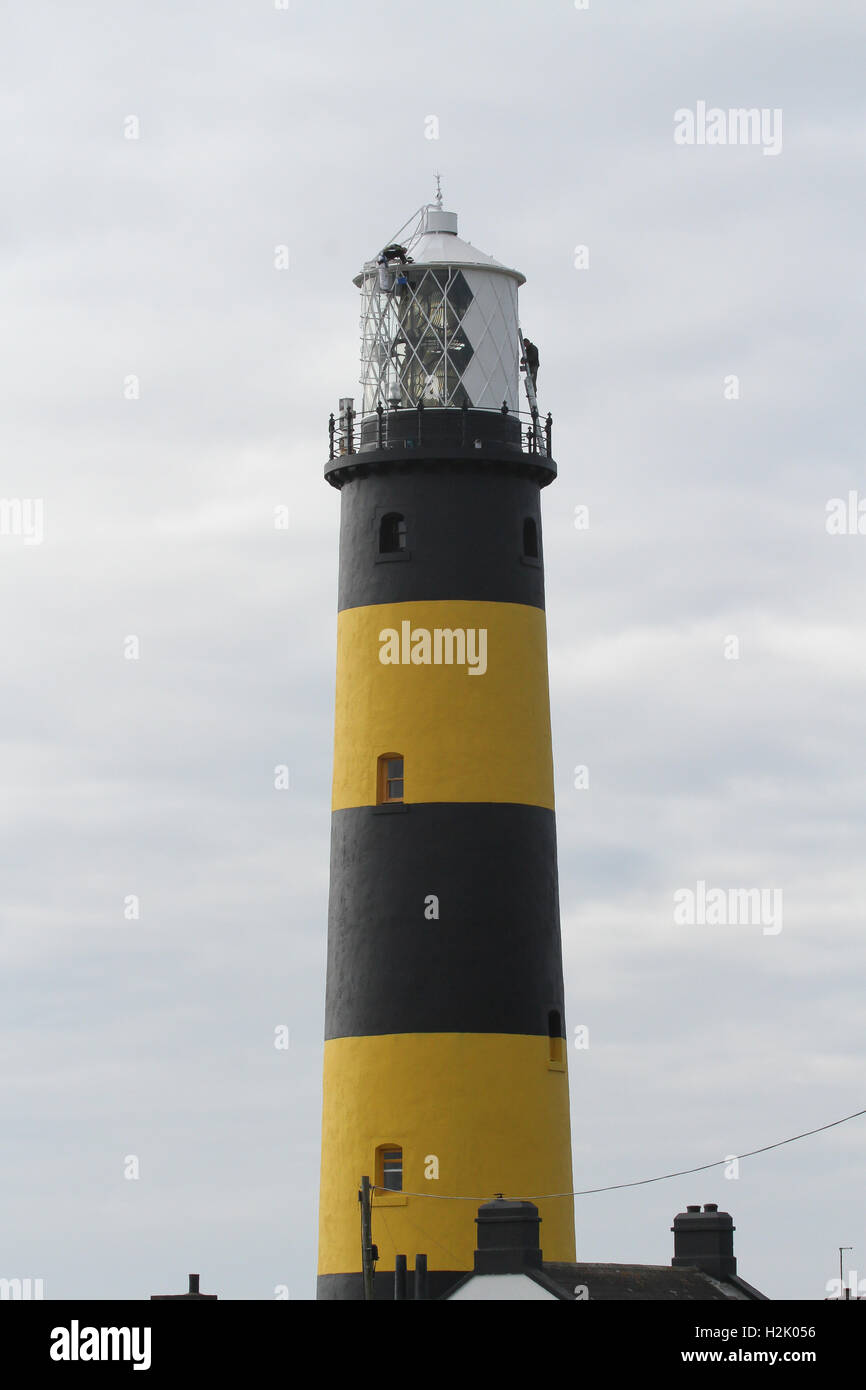 Phare peint, deux hommes peignent l'extérieur d'un phare britannique dans le comté de St John's point, en bas de l'Irlande du Nord Banque D'Images