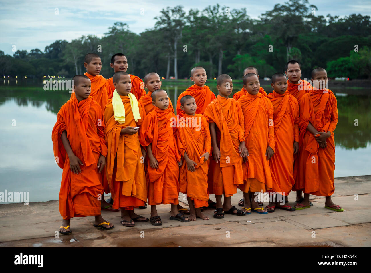 SIEM REAP, Cambodge - 30 octobre 2014 : un groupe de moines bouddhistes novice en robes orange causer sur les douves d'Angkor Wat. Banque D'Images
