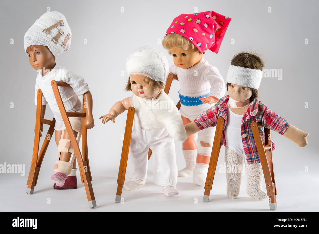 Quatre balades de poupées, des bandages sur la tête, la jambe d'une attelle, eye patch, bras et l'épaule bandage, NECK BRACE, foulard rouge Banque D'Images