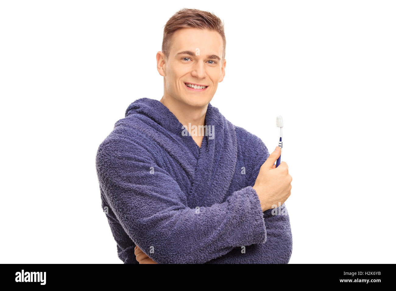 Beau gars dans un peignoir avec une brosse à dent isolé sur fond blanc Banque D'Images