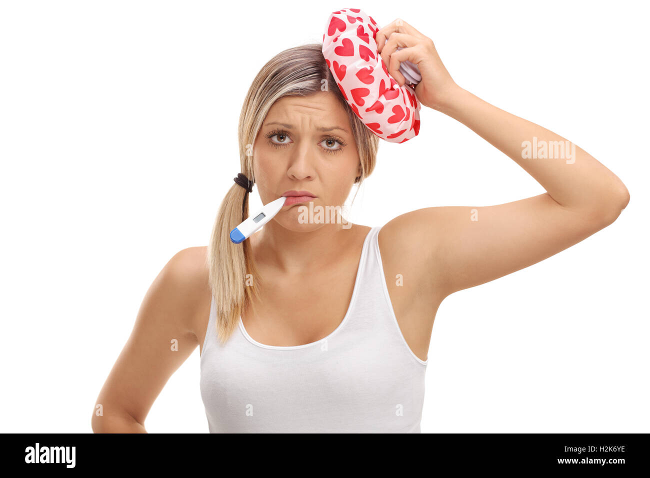 Femme malade tenant un thermomètre dans la bouche et une poche de glace sur sa tête isolé sur fond blanc Banque D'Images