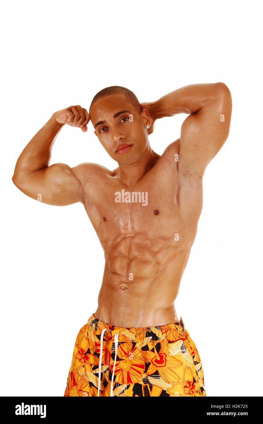 Un jeune homme debout à l'avant et de ferrer ses biceps à fond blanc. Banque D'Images