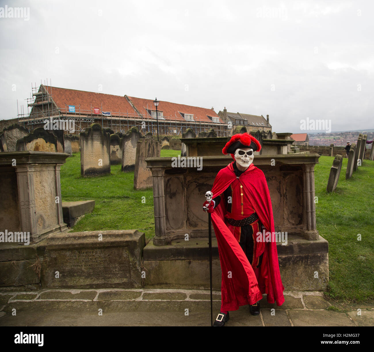 Goth avec cape rouge et masque de crâne Banque D'Images