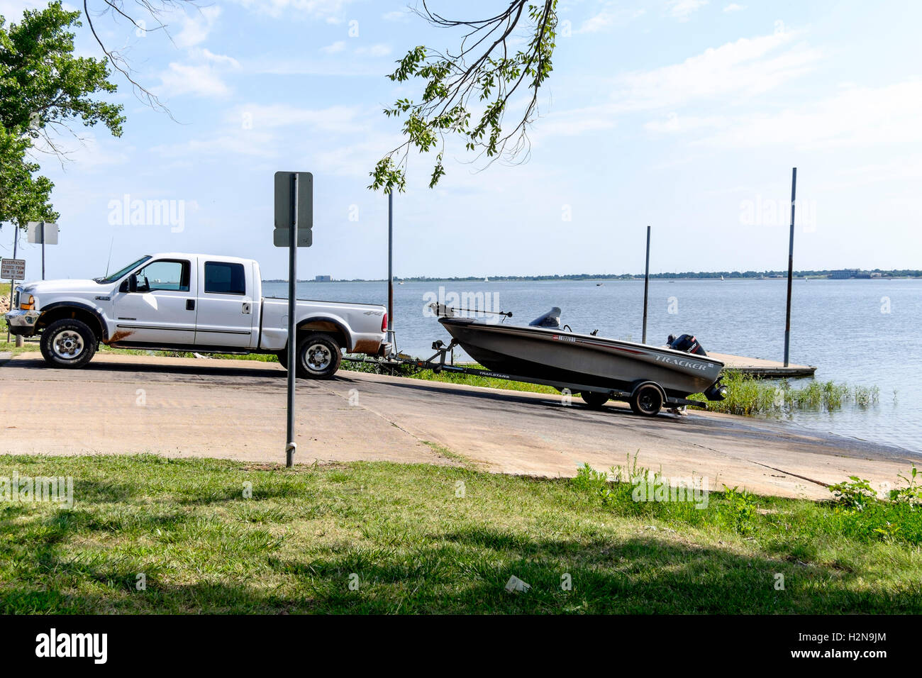 A 30-35 ans caucasien homme décharge son bateau de pêche dans un New York, USA Lake dans l'été. Banque D'Images