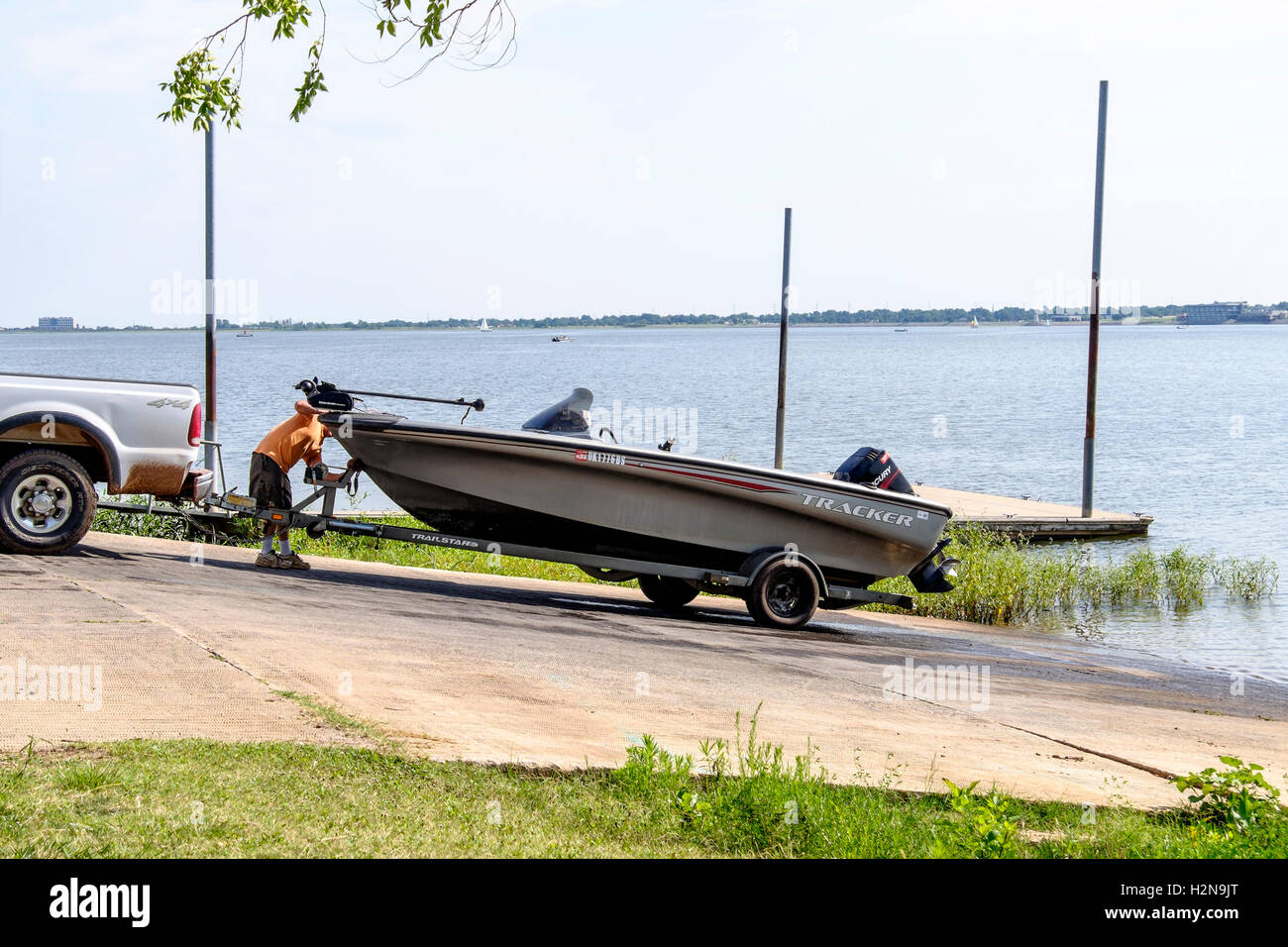 A 30-35 ans caucasien homme décharge son bateau de pêche dans un New York, USA Lake dans l'été. Banque D'Images