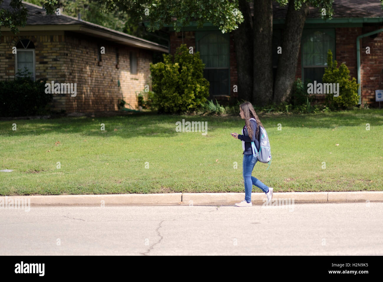 Un jeune de 14 ans Caucasian middle-school girl walking accueil après les cours à Oklahoma City, Oklahoma, USA. Banque D'Images