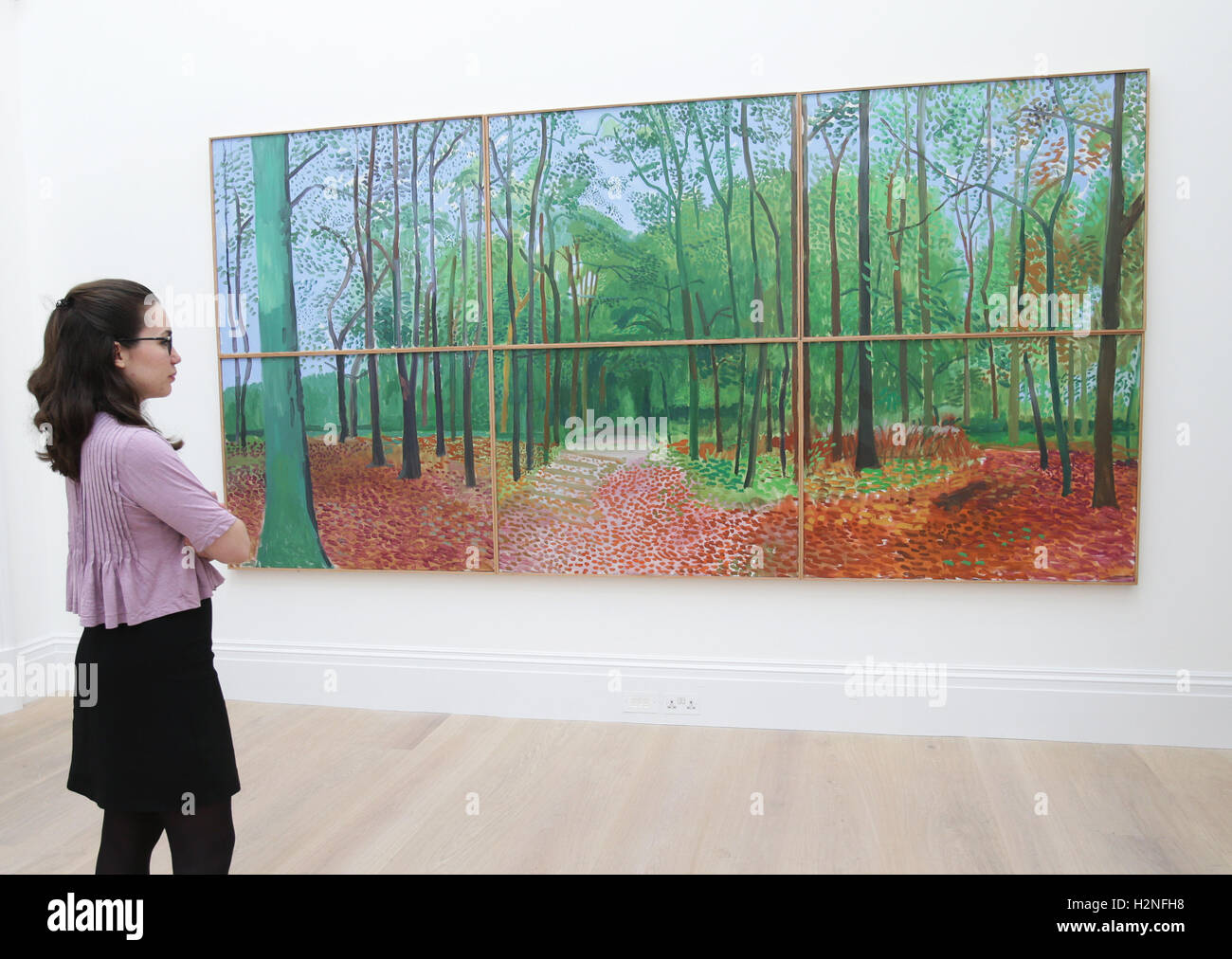 Un membre du personnel de Sotheby's à Londres admire la peinture de David Hockney Woldgate Woods, les 24, 25 et 26 octobre 2006, qui devrait rapporter jusqu'à 12 millions de dollars ('‚ £ 9.2 millions) lorsqu'elle sera sous le marteau de Sotheby's à New York le mois prochain. Banque D'Images