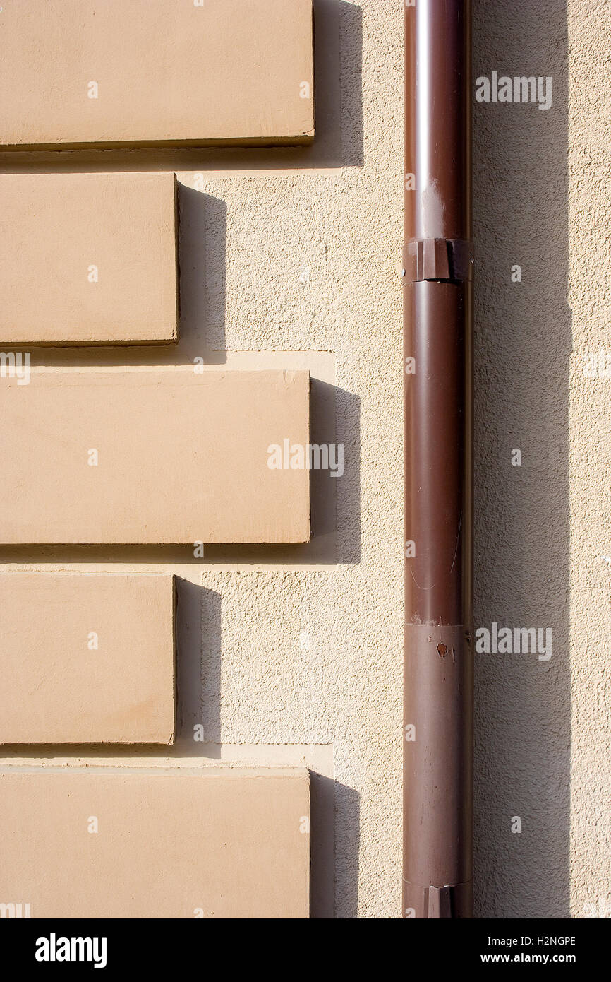 Tuyau de descente pluviale (Brown, downtake tube, tuyau de drainage, de pluie, d'eaux pluviales tuyau tuyau) avec un motif sur un mur de la façade de l'immeuble. Banque D'Images