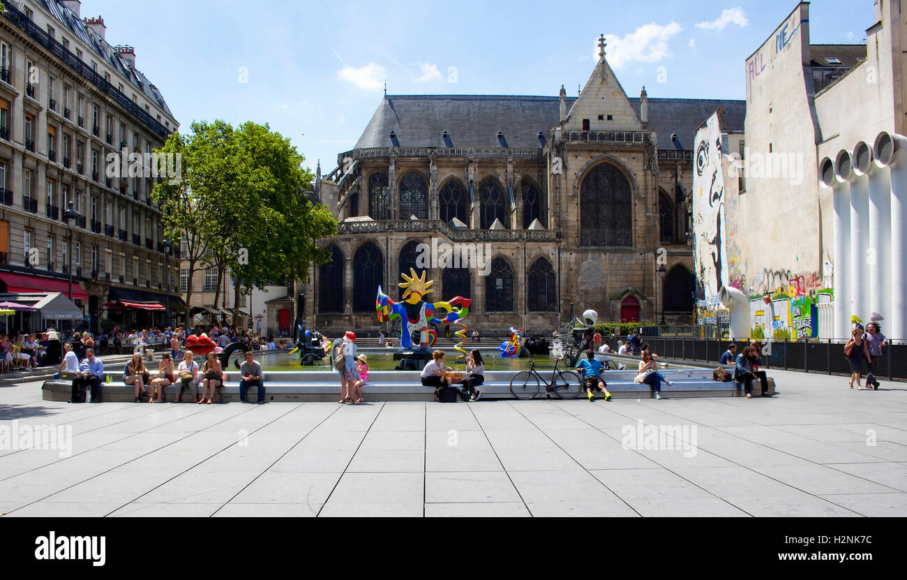 Les gens s'assoient autour de la fontaine Stravinsky et profiter des beaux jours à Paris. Il y a beaucoup d'œuvres contemporaines dans la piscine. Banque D'Images