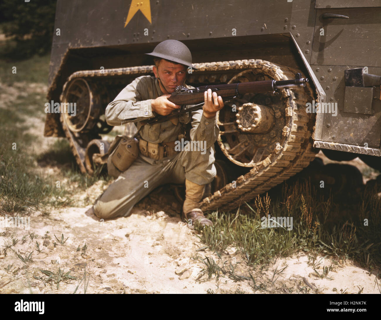 Jeune soldat visant Garland Carabine près de Armored Tank, Fort Knox, Kentucky, USA, Alfred T. Palmer pour l'Office of War Information, Juin 1942 Banque D'Images