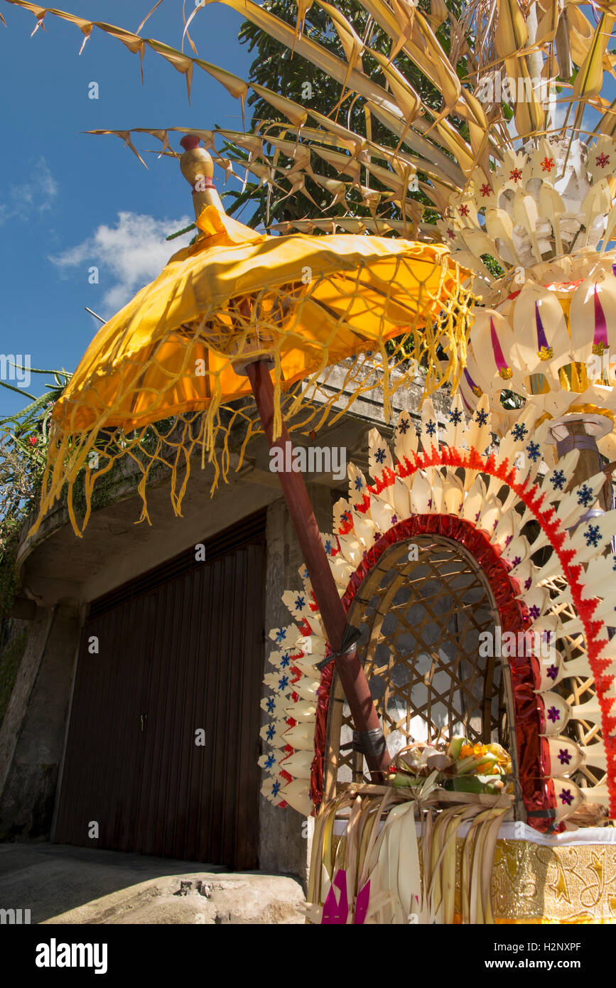 L'INDONÉSIE, Bali, Putung Kuningan, festival, avec des décorations à l'intérieur offrant penjor ombragée par parasol Banque D'Images