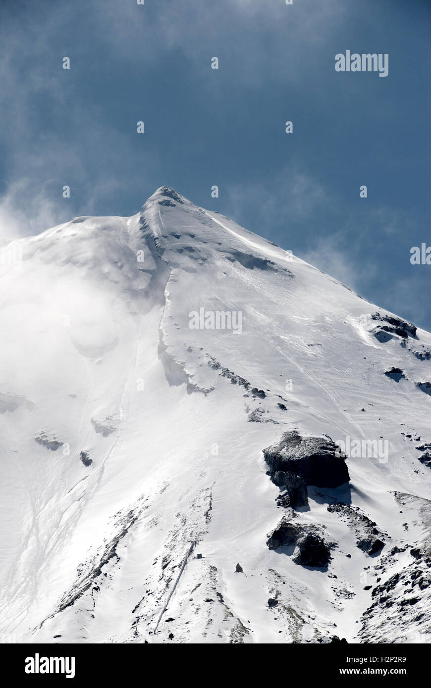 Sommet du Mont Taranaki, en Nouvelle-Zélande. Des vents forts soufflent nuages sur le sommet. Banque D'Images