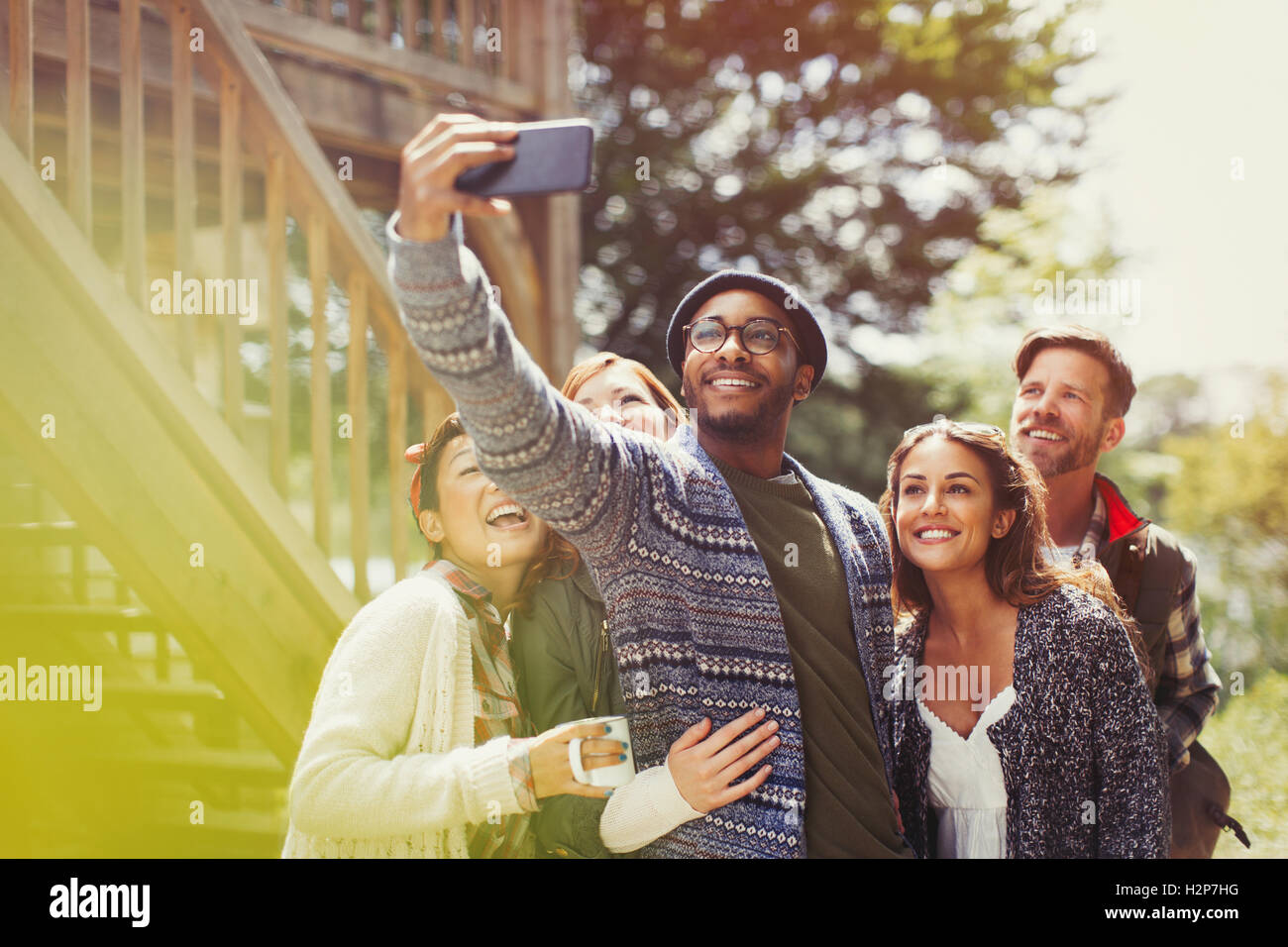 Smiling friends avec téléphone appareil photo en tenant l'extérieur selfies Banque D'Images