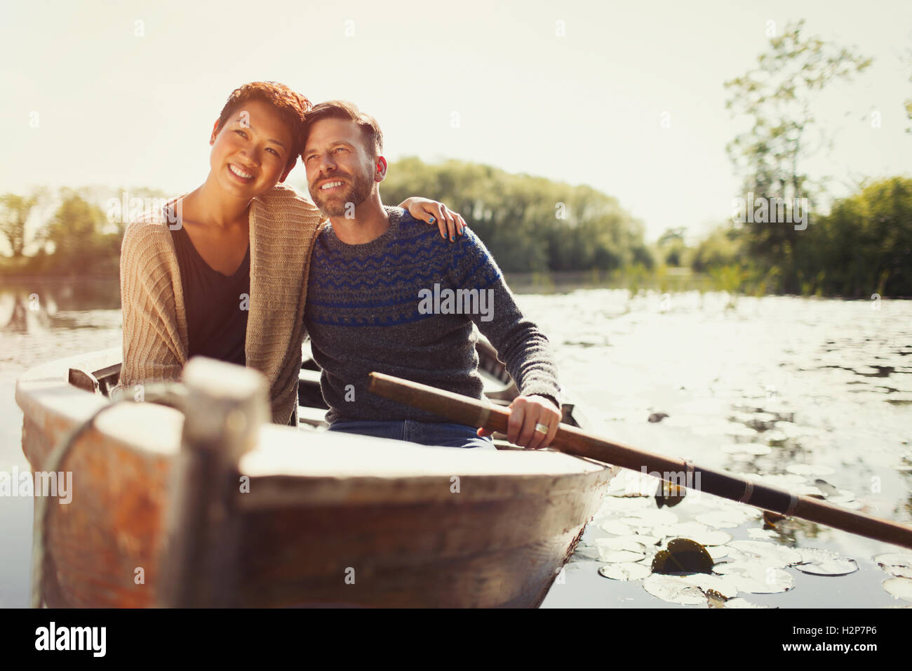 Portrait couple hugging canoë sur le lac Sunny Banque D'Images