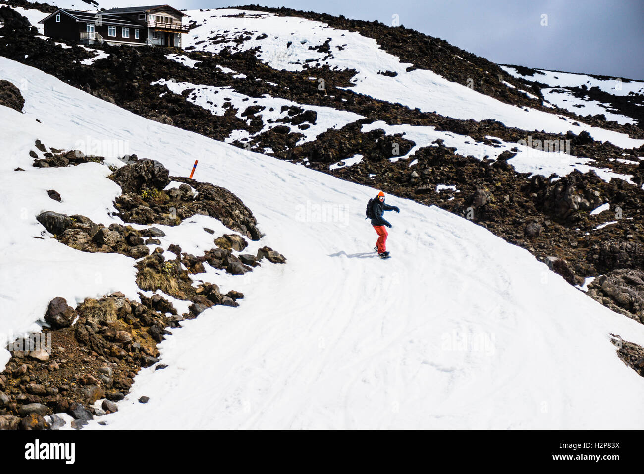 Un homme snowboard en bas de la colline du haut du mont Ruapehu Banque D'Images