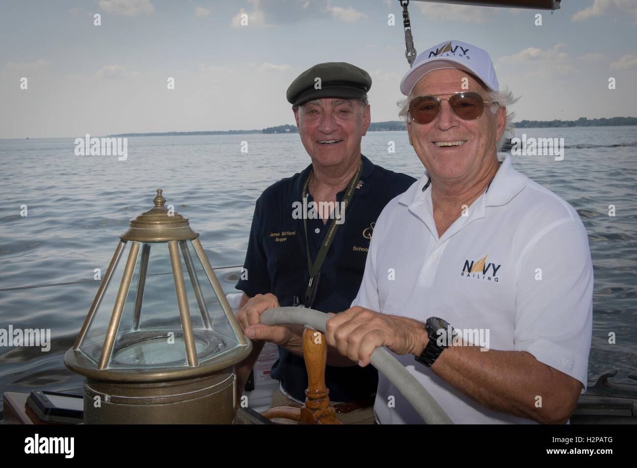 Singer Jimmy Buffett, droite, s'essaie à la tête de l'académie navale des États-Unis avec skipper Voilier formation Summerwind James Maitland dans la baie de Chesapeake, le 8 septembre 2016, à Annapolis, Maryland. Buffett a rejoint l'Académie Navale Sailing Foundation pour la journée de la voile sur la Summerwind et l'America. Banque D'Images