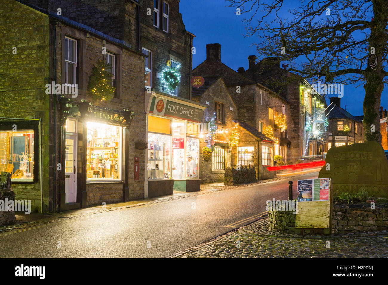 Lumières de Noël coloré égayer une sombre soirée d'hiver - Malham Village, Yorkshire Dales National Park, England. Banque D'Images