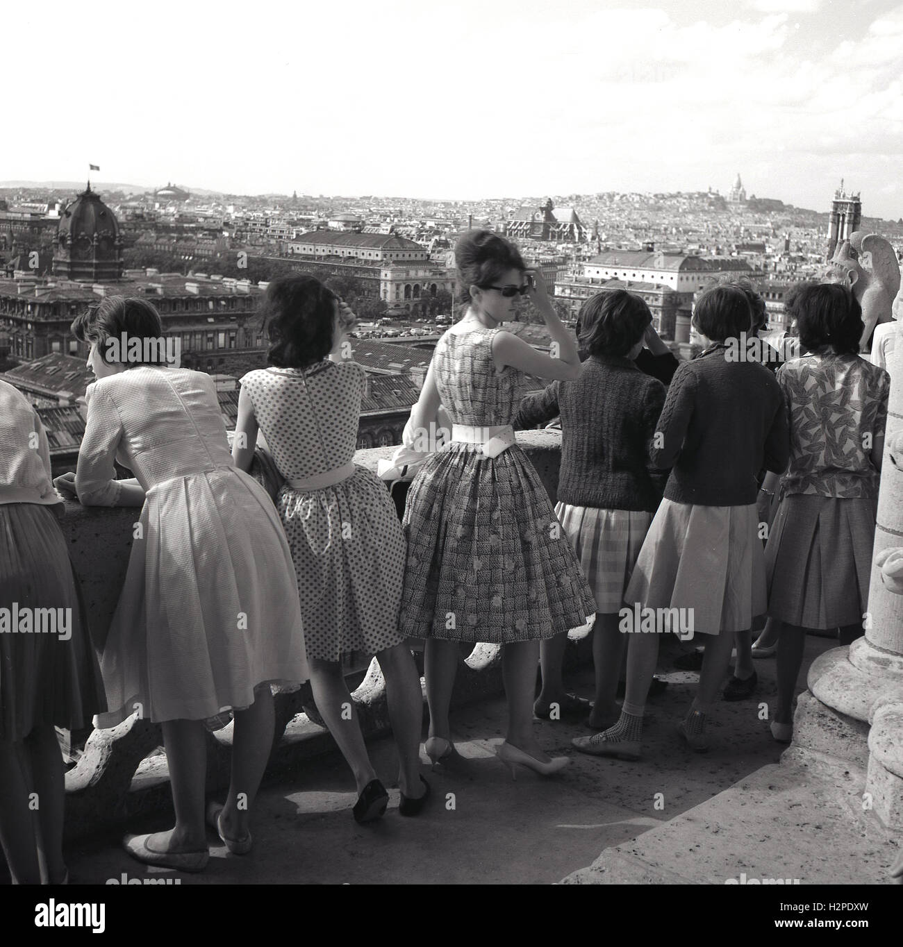 Années 1950, historique, groupe de jeunes femmes en robes d'oeil sur les toits de Paris du haut de la Cathédrale Notre Dame, Paris, France. Banque D'Images