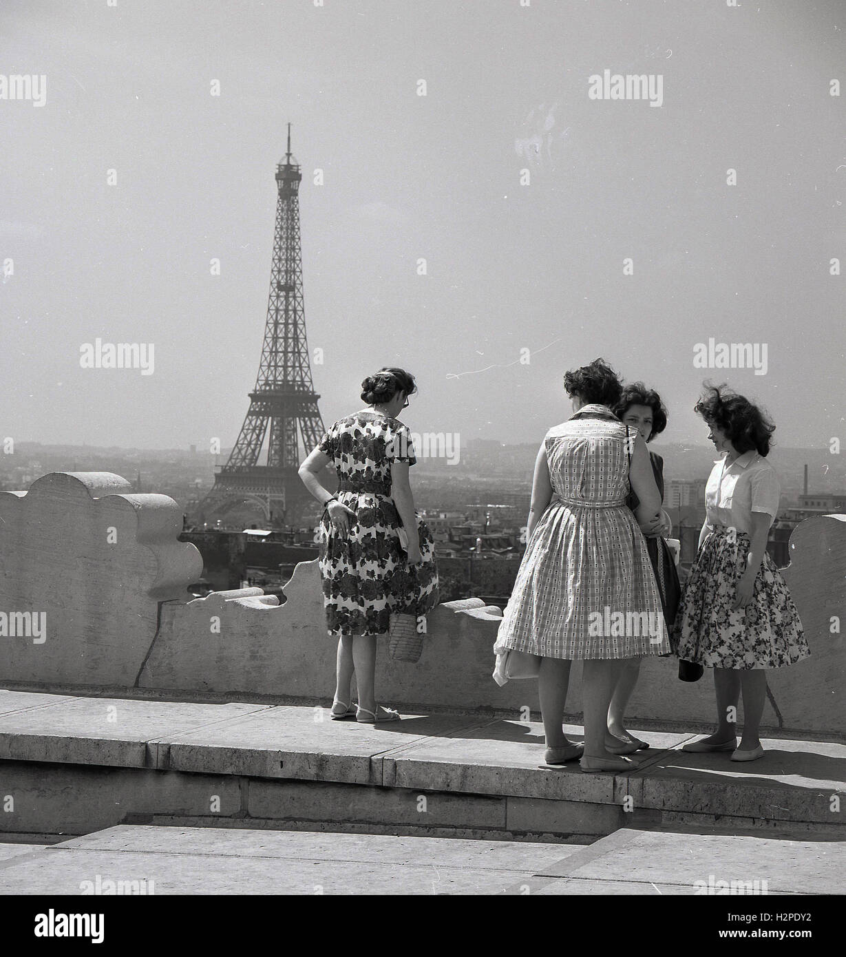 Années 1950, historiques, mesdames parler ensemble au sommet d'un bâtiment avec la Tour Eiffel au loin, Paris, France. Banque D'Images