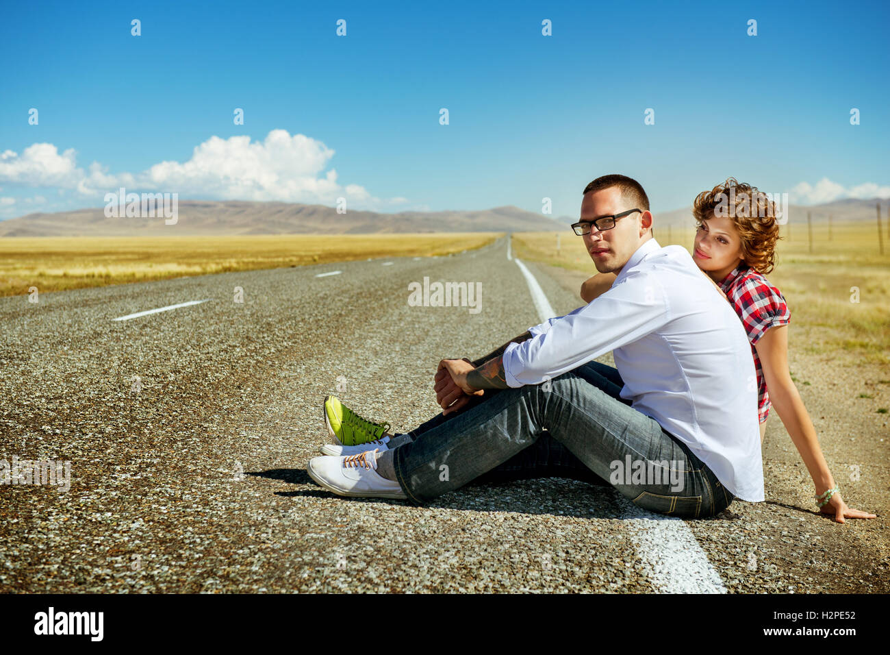 Love couple est assis sur la route dans les montagnes Banque D'Images