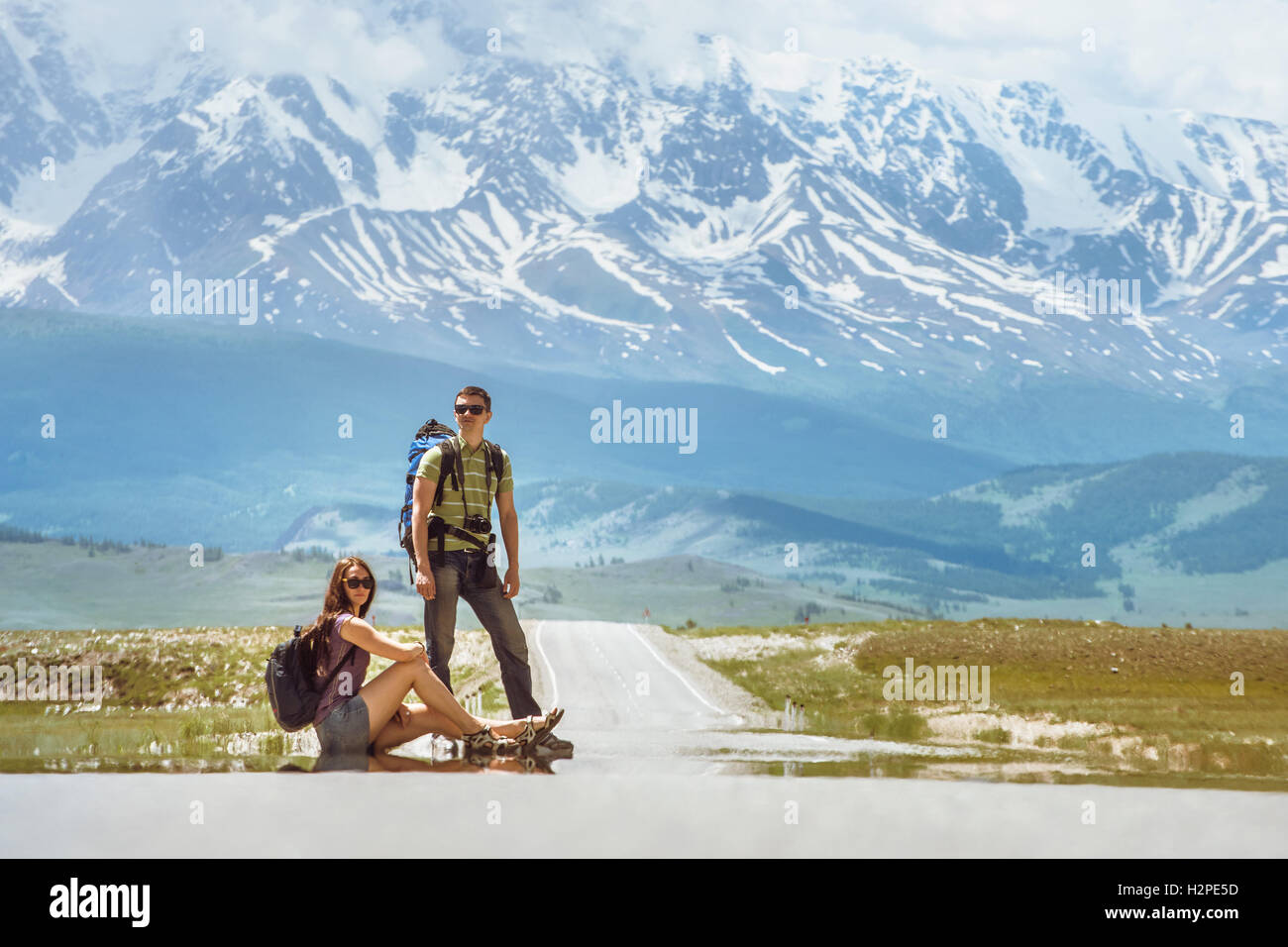 Couple de voyageurs reste sur la route dans les belles montagnes Banque D'Images