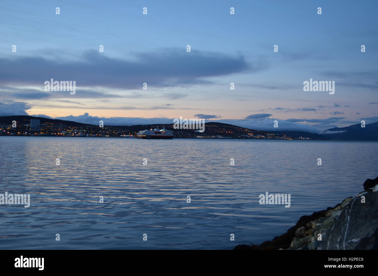 Hammerfest, NORVÈGE - 29 septembre 2016 : l'express côtier norvégien Hurtigruten, laissant Tromsoe, ville au coucher du soleil Banque D'Images