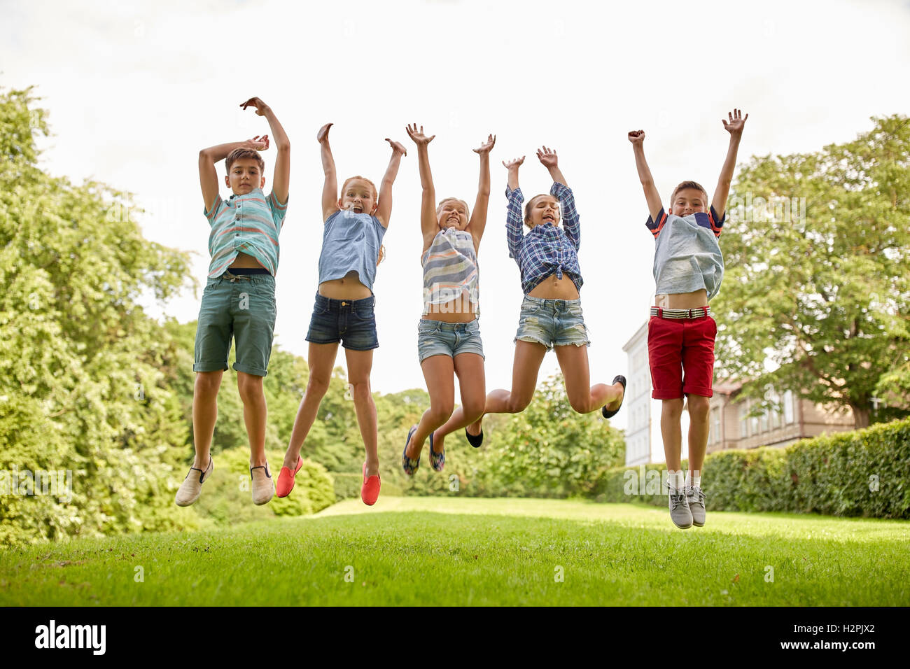 Enfants heureux de sauter et s'amuser dans le parc d'été Banque D'Images