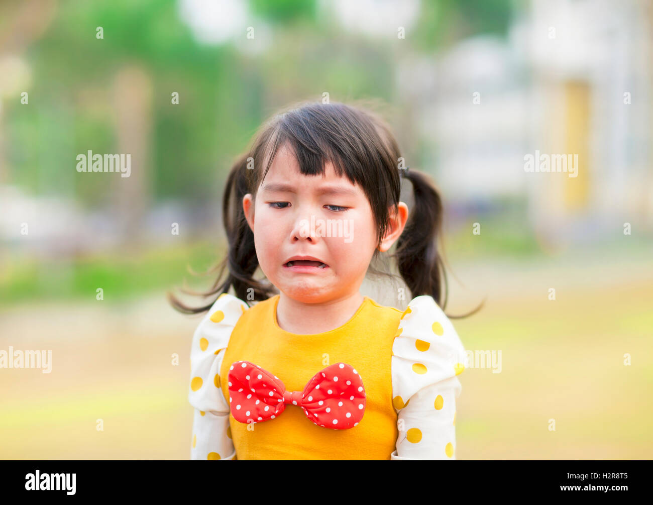 Petite fille pleurer dans le parc Banque D'Images