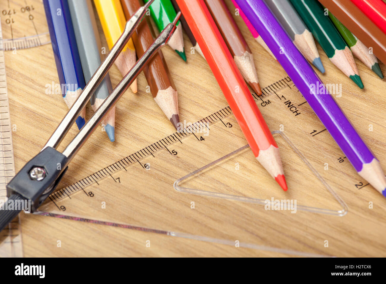 Des crayons renversé sur un bureau en bois avec un rapporteur d'établir Banque D'Images