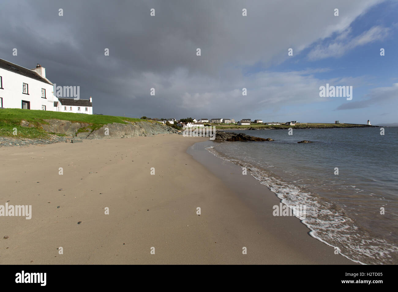 Île d'Islay, en Écosse. Vue pittoresque de cottages côte doublure rue de Port Charlotte, avec la plage au premier plan. Banque D'Images