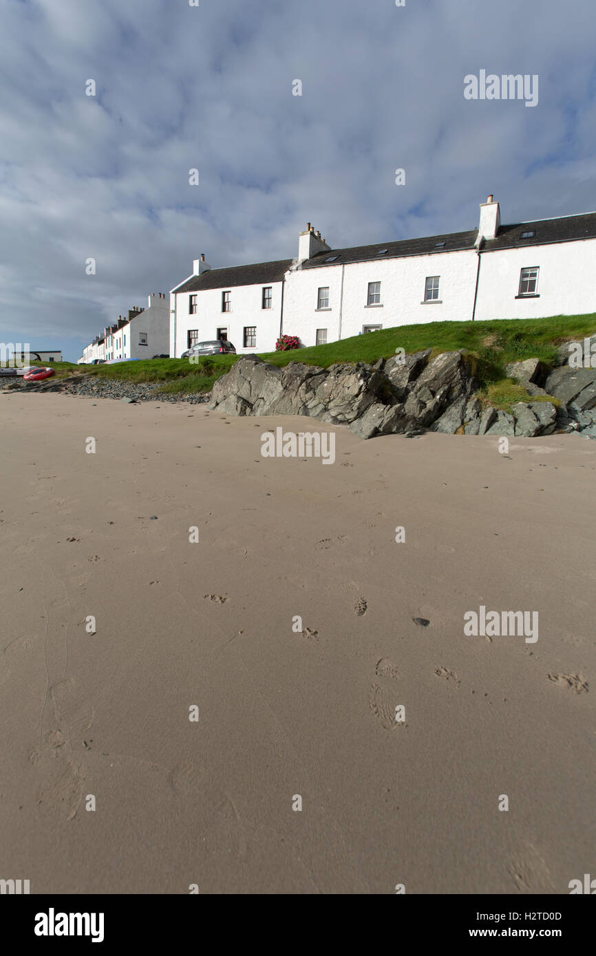 Île d'Islay, en Écosse. Vue pittoresque de cottages côte doublure rue de Port Charlotte, avec la plage au premier plan. Banque D'Images