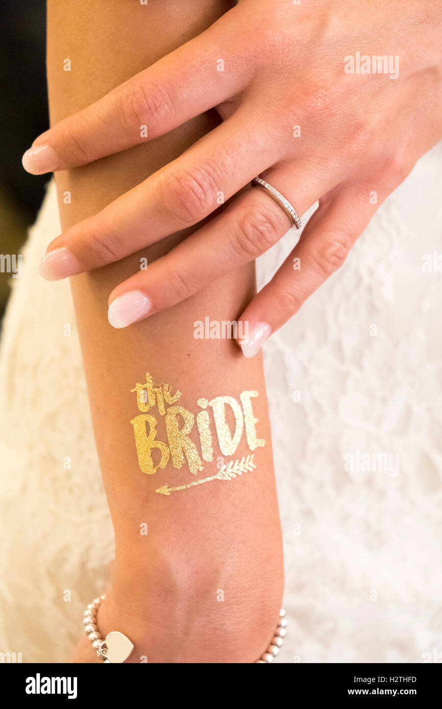 Bague de mariage show main de femme mariée et texte d'or tattoo glitter Banque D'Images