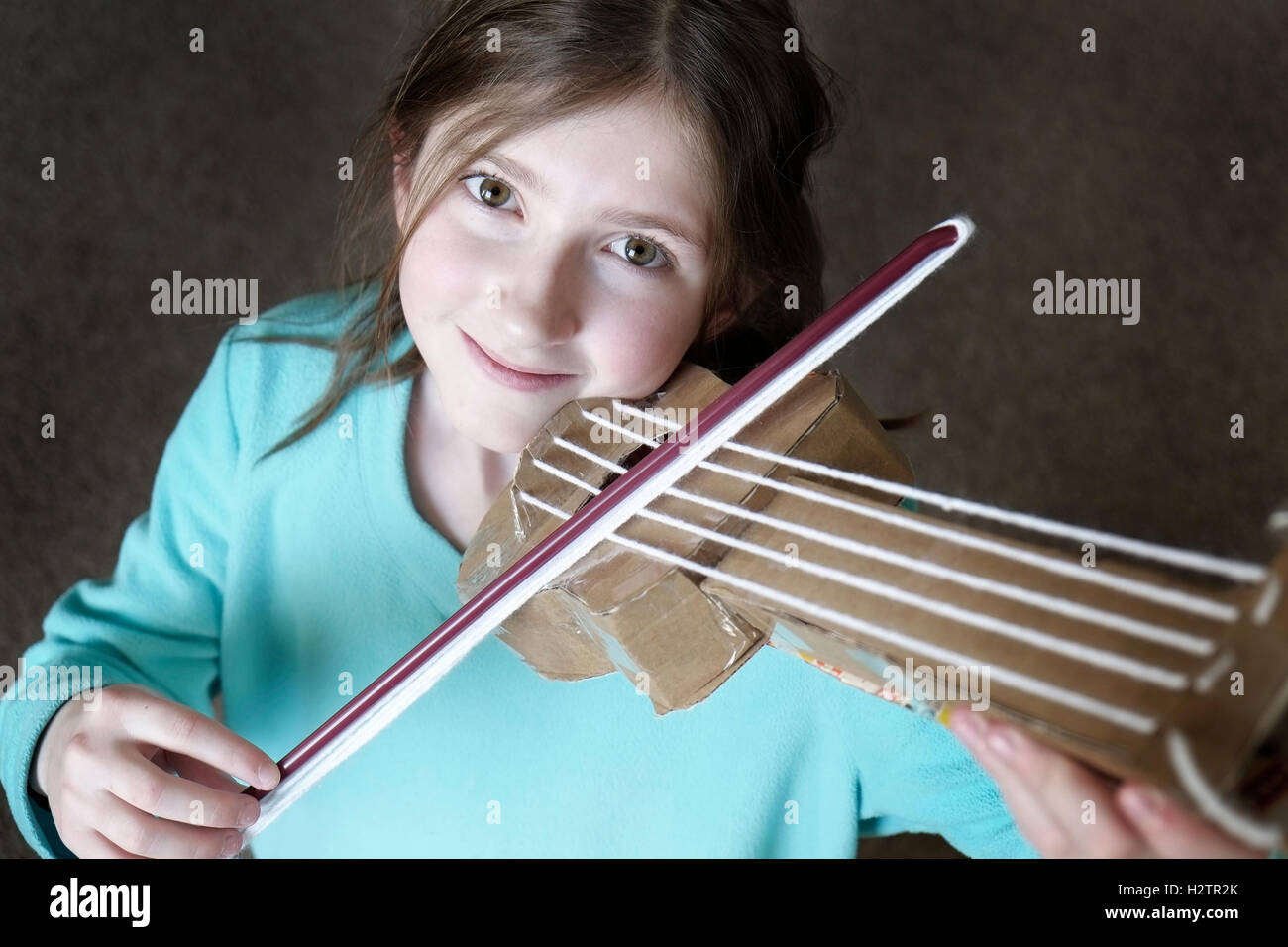Jeune fille jouant du violon jouet smiling happy Banque D'Images