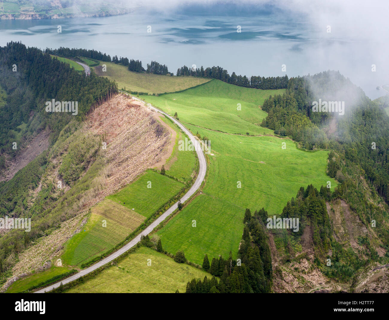 Curving Road entre Lagoa Azul et Santiago. La brume se déplace sur une route qui tourne au sommet du cratère, entre deux lacs volcaniques. Banque D'Images