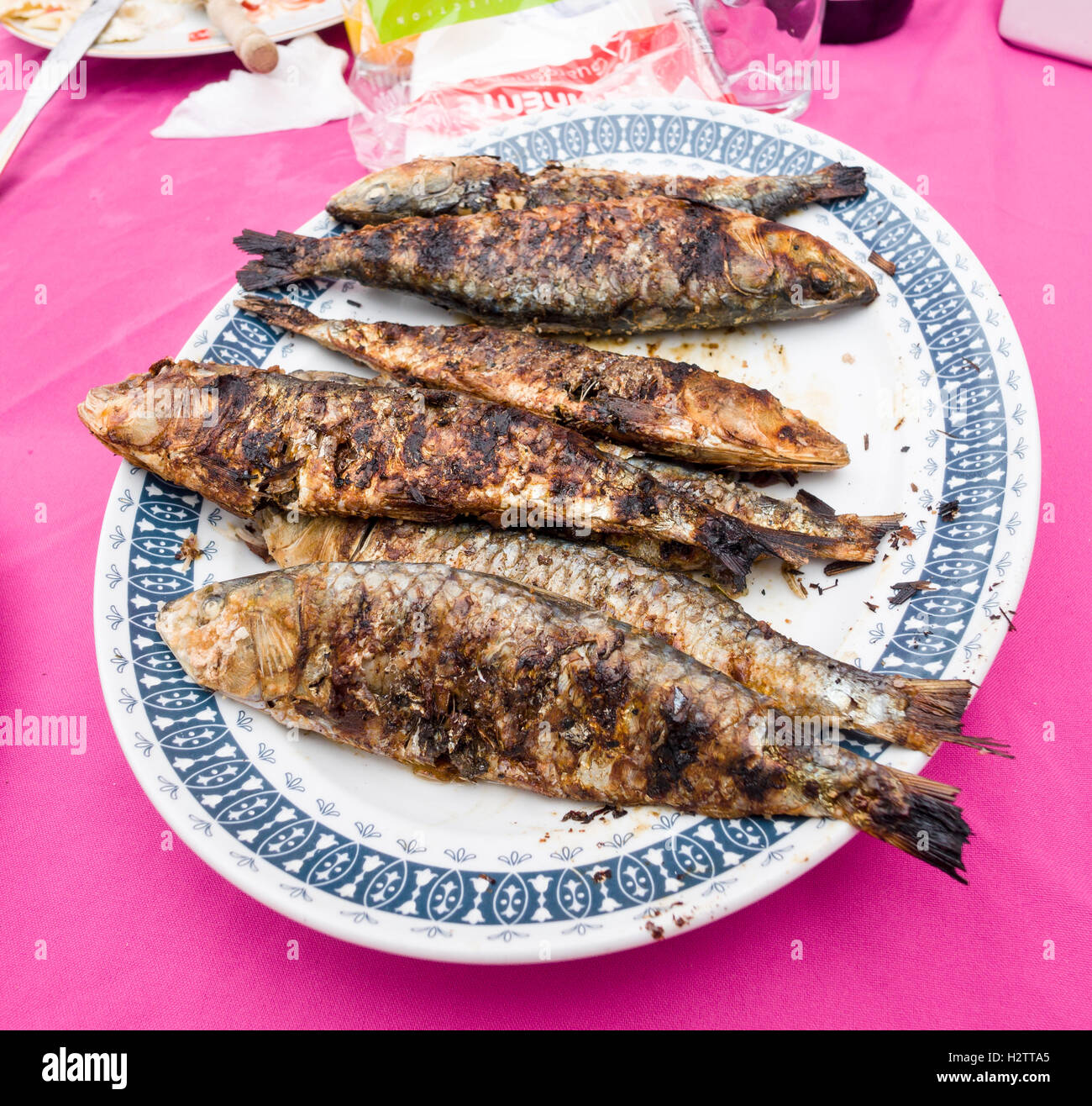 Une assiette de sardines grillées. Six de maquereau ou de sardine grillée à la perfection sur une assiette ovale. Banque D'Images